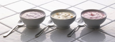  Three fruit yoghurt bowls on a white tile background 