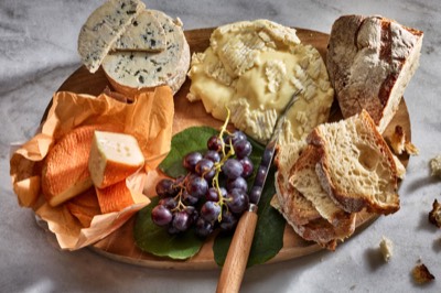  Cheese, bread and grapes on aa wood board 